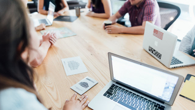 A group of employees sitting on table and having important discussion during a meeting.