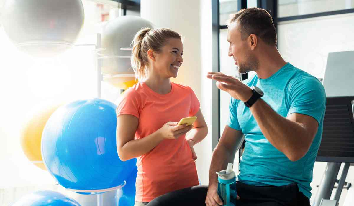 Two partners are seen discussing during their workout. Giving each other exercise motivation.