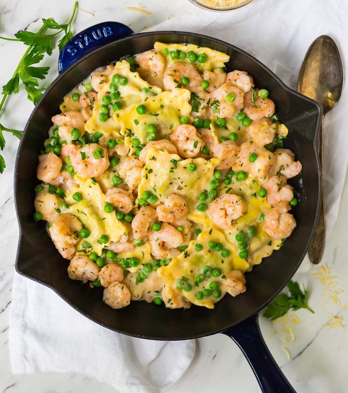 Shrimp and ravioli plated with fresh herbs and garlic sauce