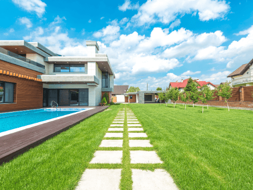 Modern home with a pool and stepping stone path surrounded by lush artificial grass front yard ideas for stylish outdoor living.