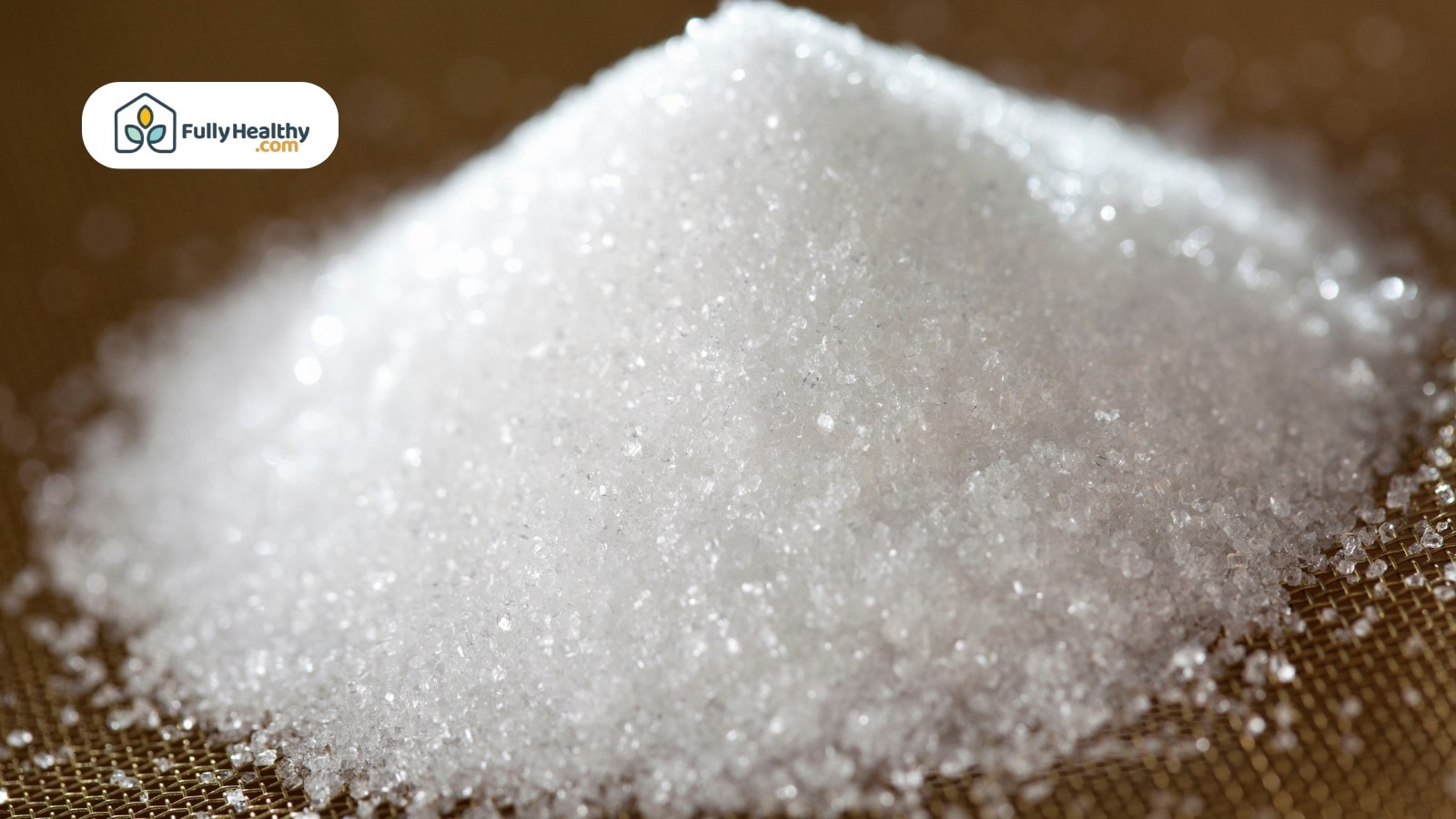Closeup of white granulated sugar pile on mesh surface