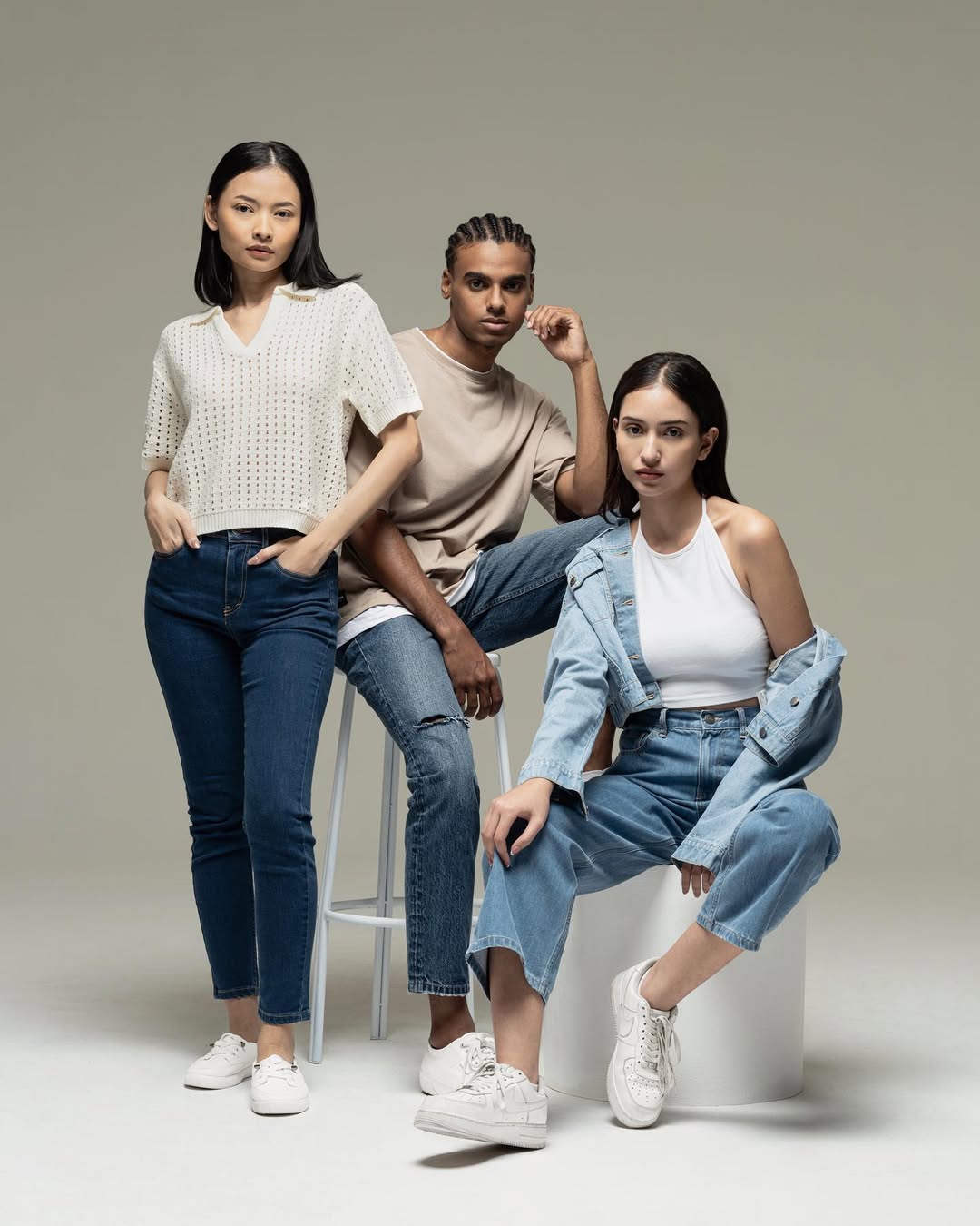 tiga wanita memakai Celana Jeans biru dan berbagai jenis atasan