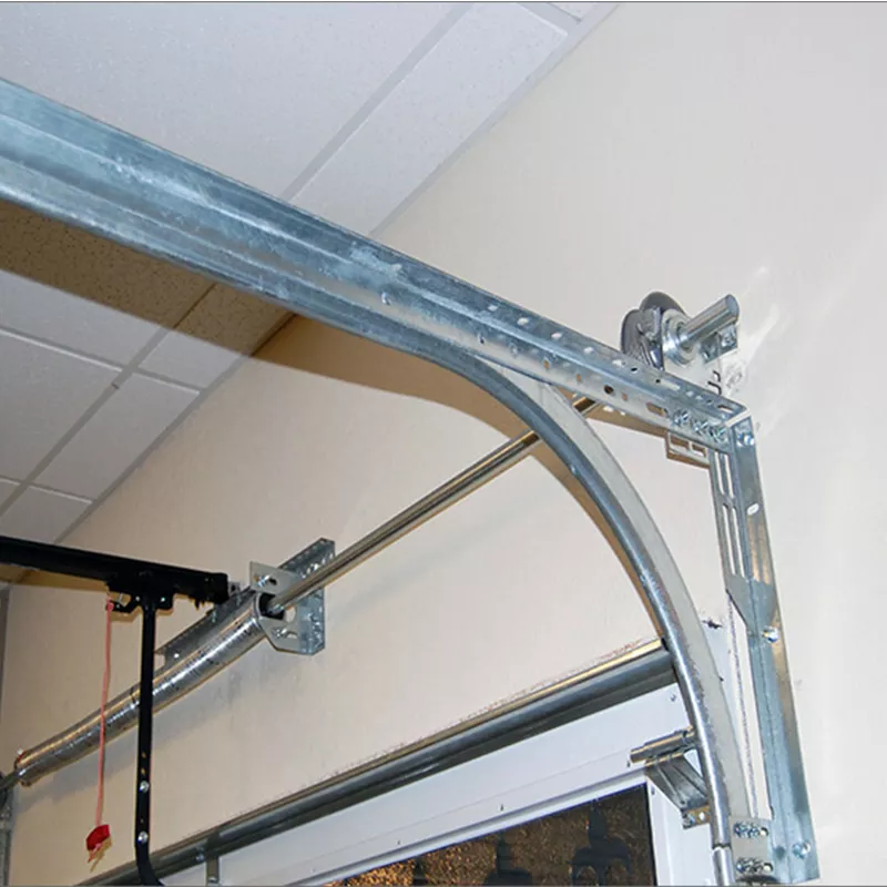 Close-up view of a garage door track and roller system, showing metal brackets and rails securely installed on a wall and ceiling for smooth door operation