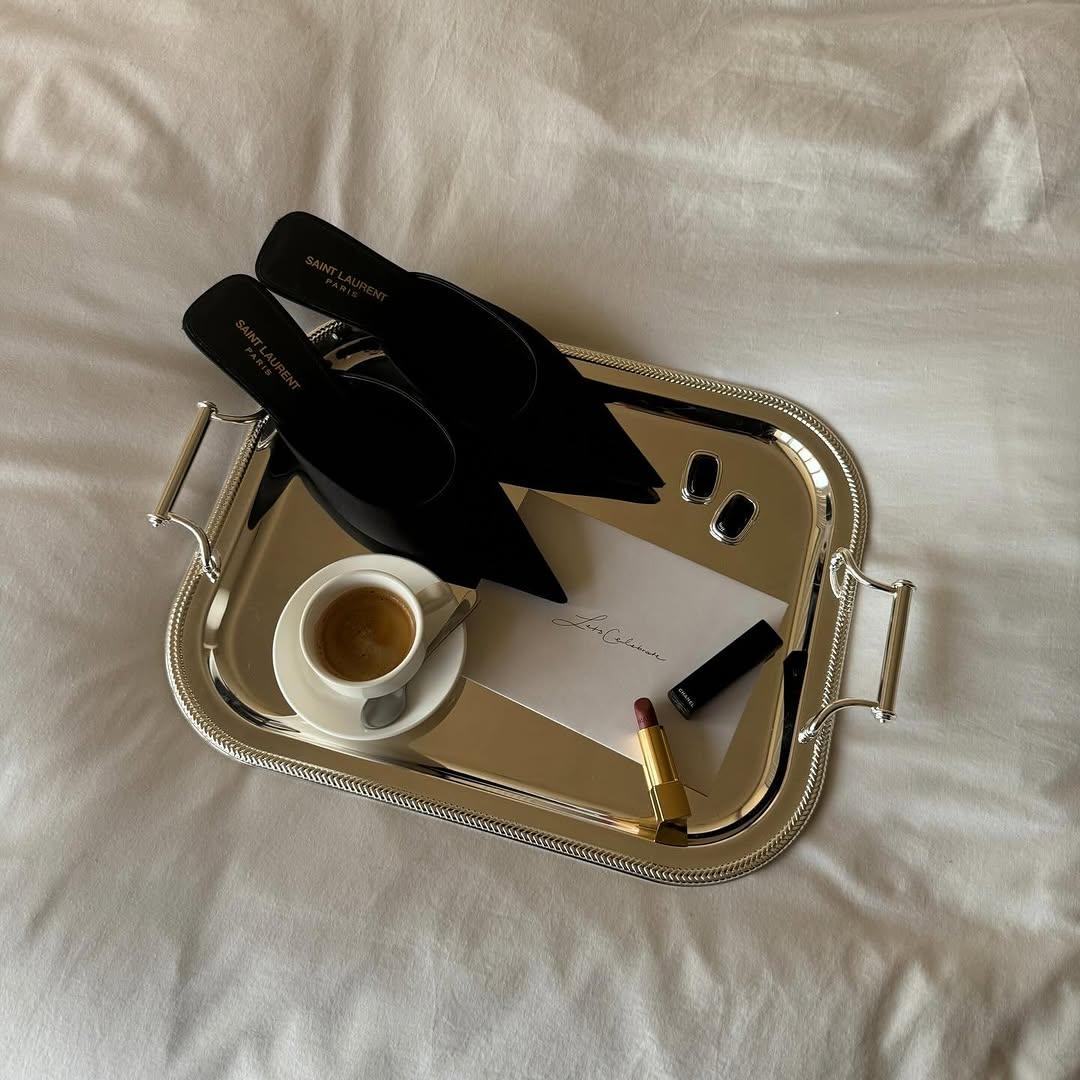 A tray with a cup of coffee and shoes on it

Description automatically generated