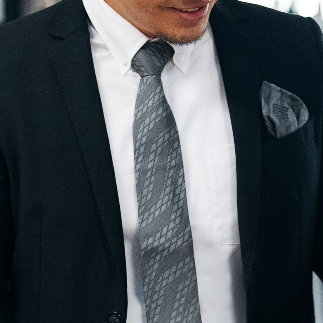 An image showing a closeup image of men wearing batik neck tie and pocket square set in grey snakeskin from batik boutique