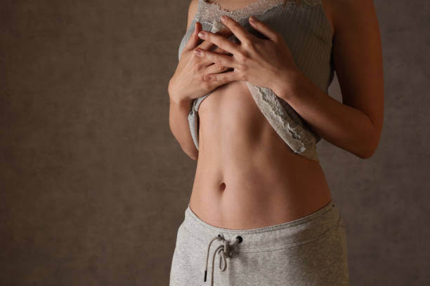 Healthy woman with a flat stomach, showing potential weight management benefits of Akkermansia