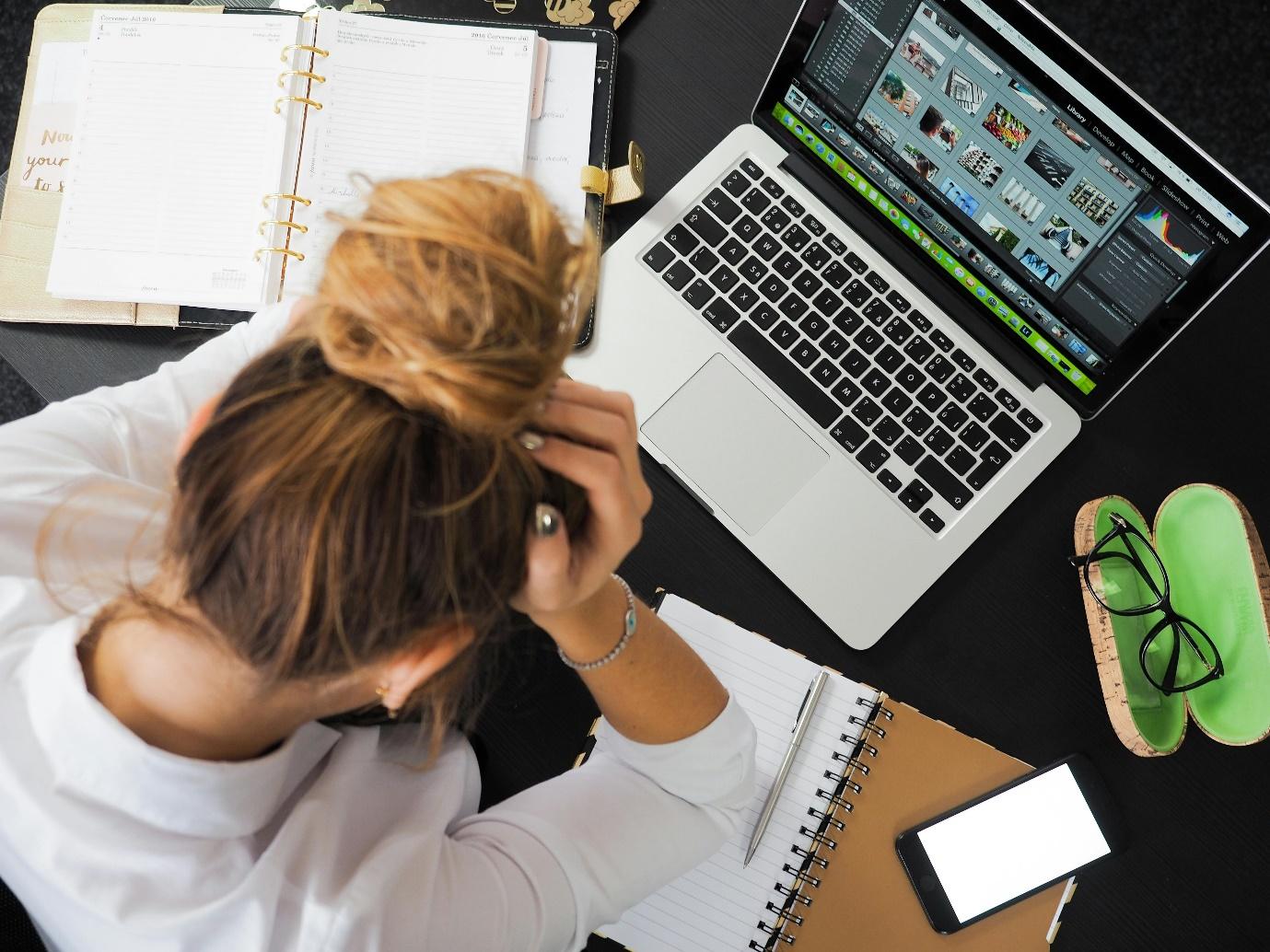 A person sitting at a desk with a computer and a phone

Description automatically generated