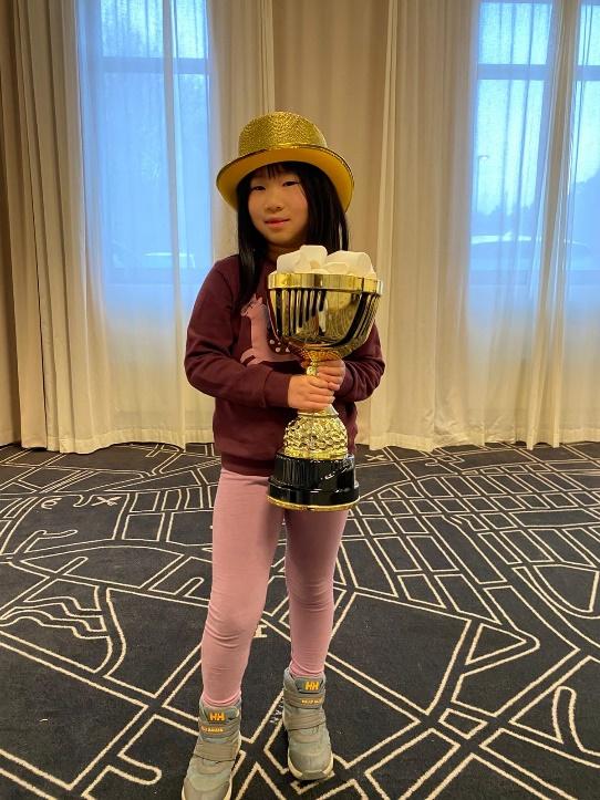 A child holding a trophy

Description automatically generated