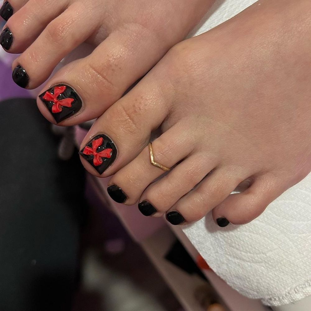 Close up of foot with radiant toe nail having Red and Black Toe Nail Designs