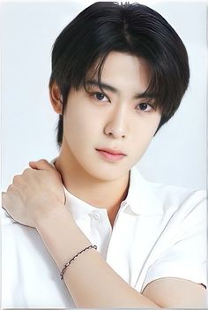 This contains an image of Jaehyun on a white shirt putting hand on his shoulder 