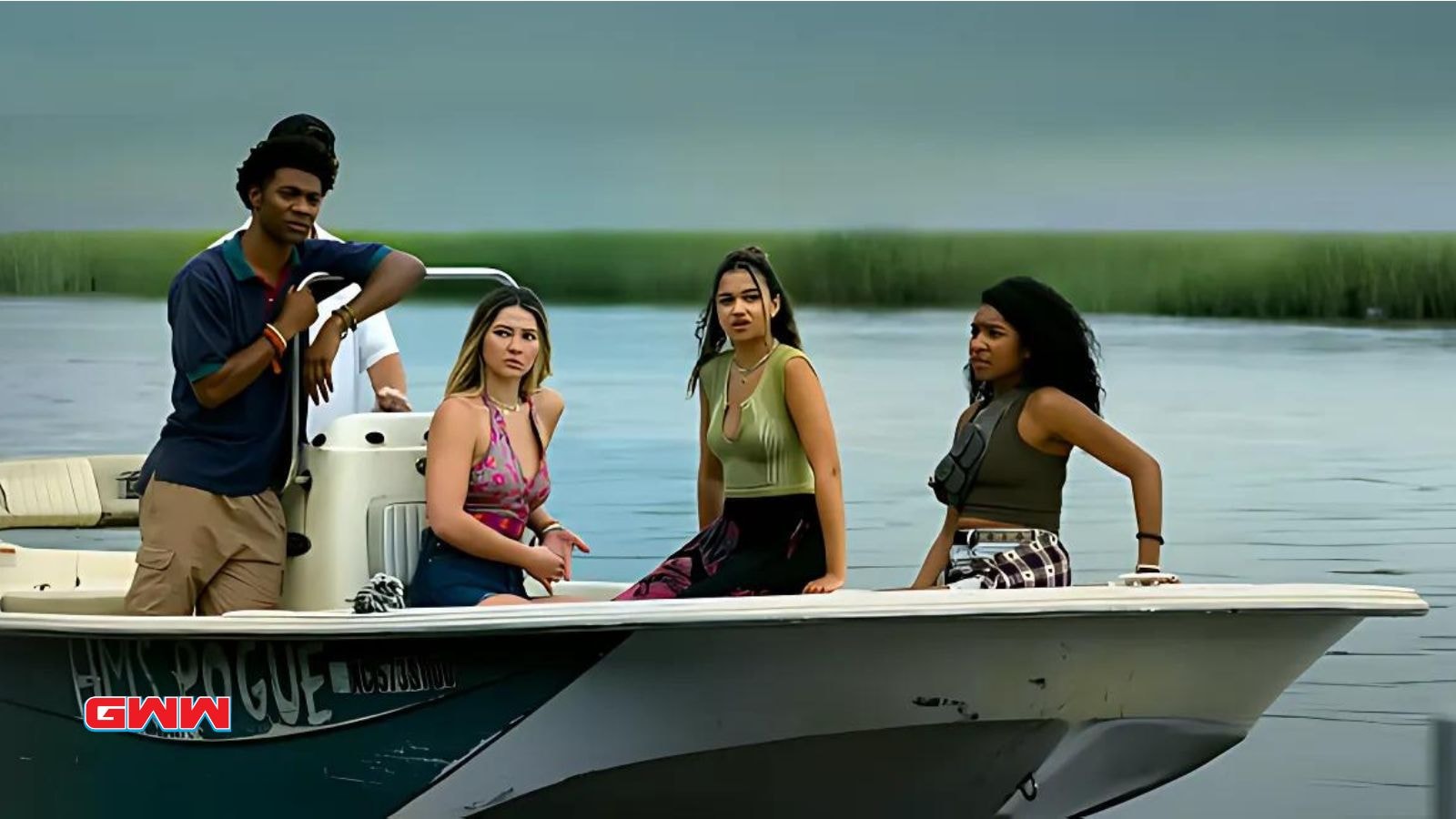 Outer Banks cast on a boat, featuring Jonathan Daviss, Madelyn Cline, Madison Bailey