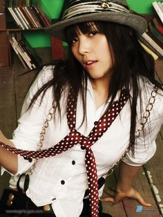 This an image of Sunye wearing a hat and tie with a white dress