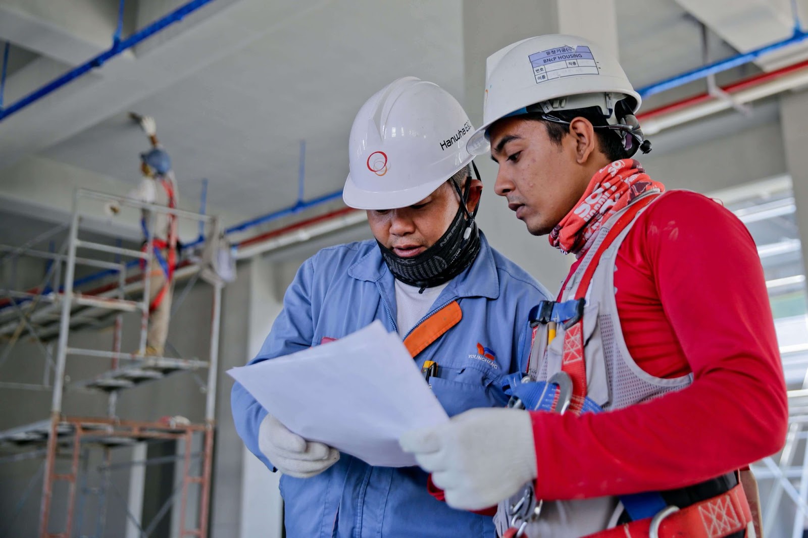 Two contractors discussing and holding a report.