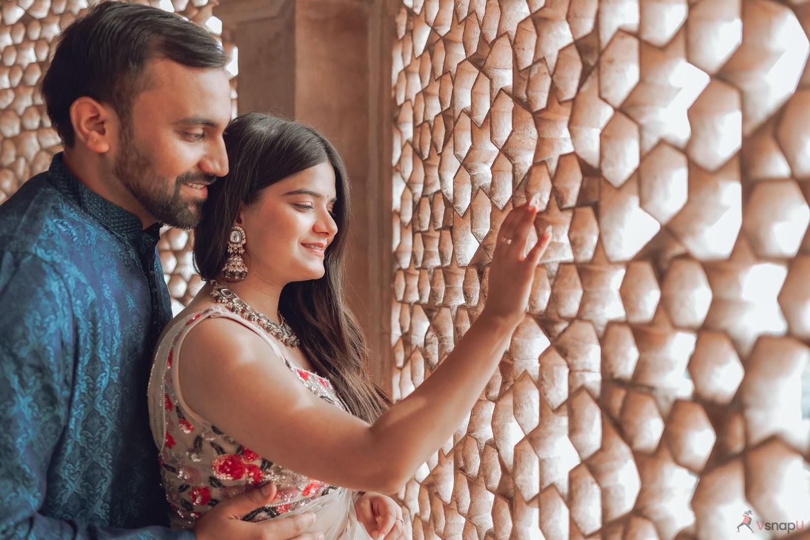 Romantic pre-wedding photoshoot inside a historic palace, with sunlight streaming through a hole-filled wall