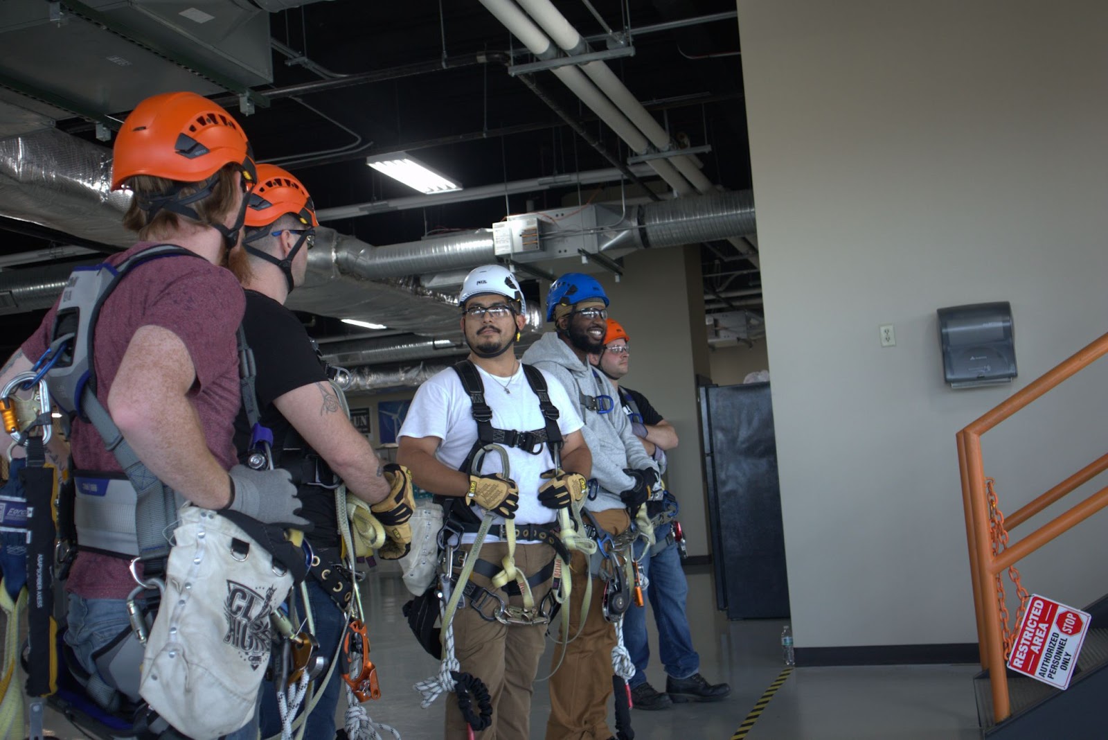 Pinnacle Career Institute Tower Technician students wearing personal protective equipment for training the students are talking and appear to be in a good mood