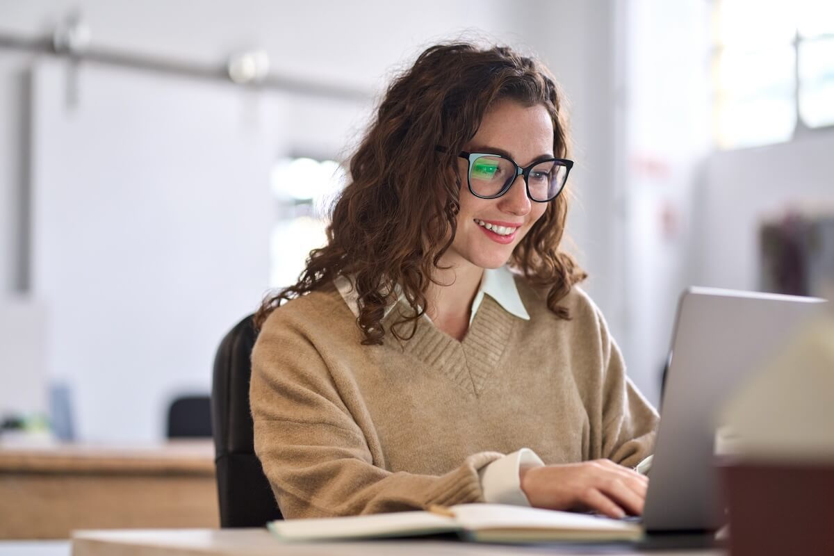 Curly-haired employee using a laptop