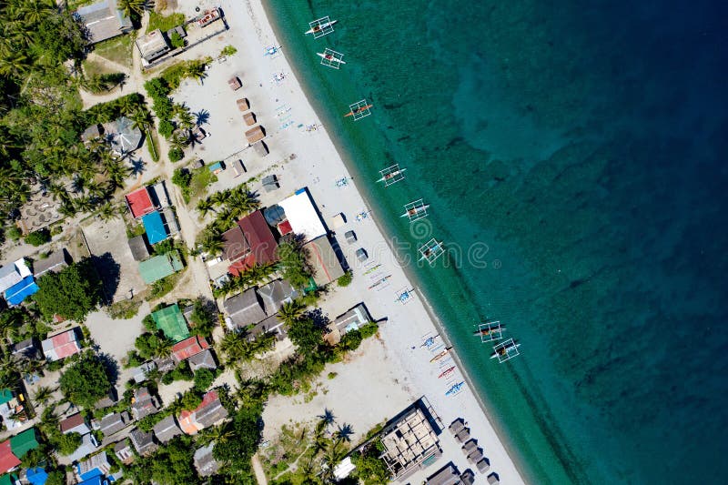 An aerial shot of the Looc Beach surrounded by the sea and buildings in Surigao, the Philippines