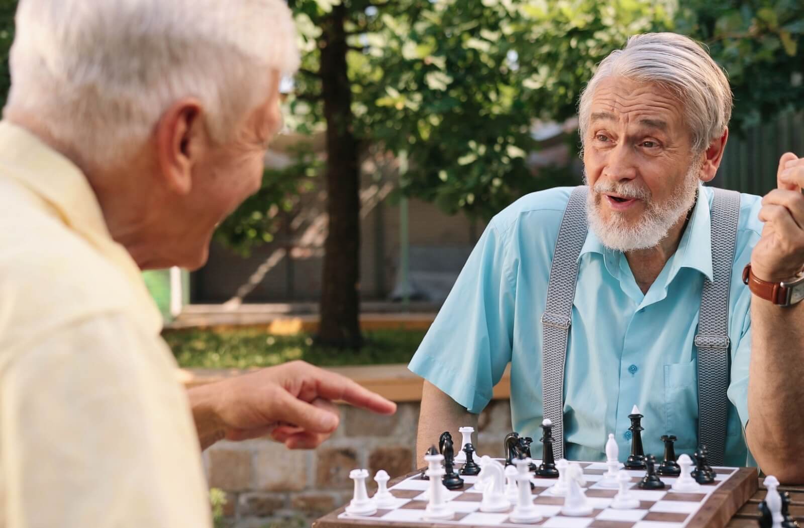 Two seniors enjoying a game of chess together at an assisted living community