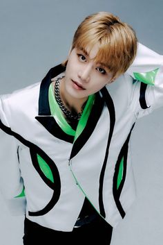 Taeil NCT on a touch  white ,green and black jacket with his hand at the back on his head 