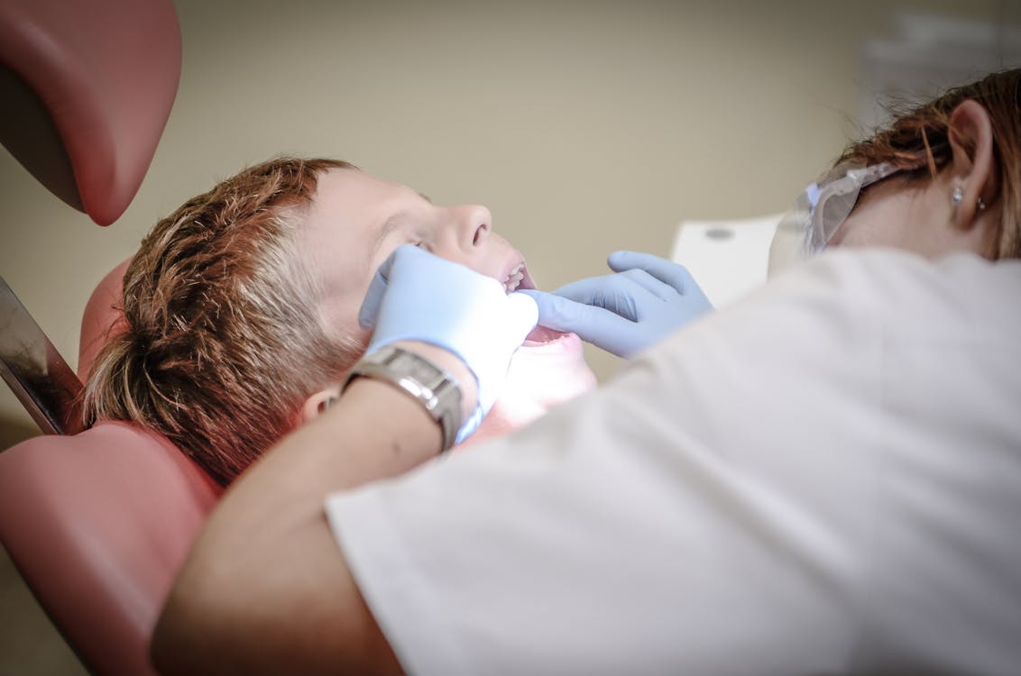 Free A young boy receiving a dental examination by a professional dentist in a clinic setting. Stock Photo