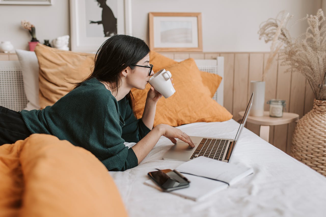 A woman on her bed with her laptop on