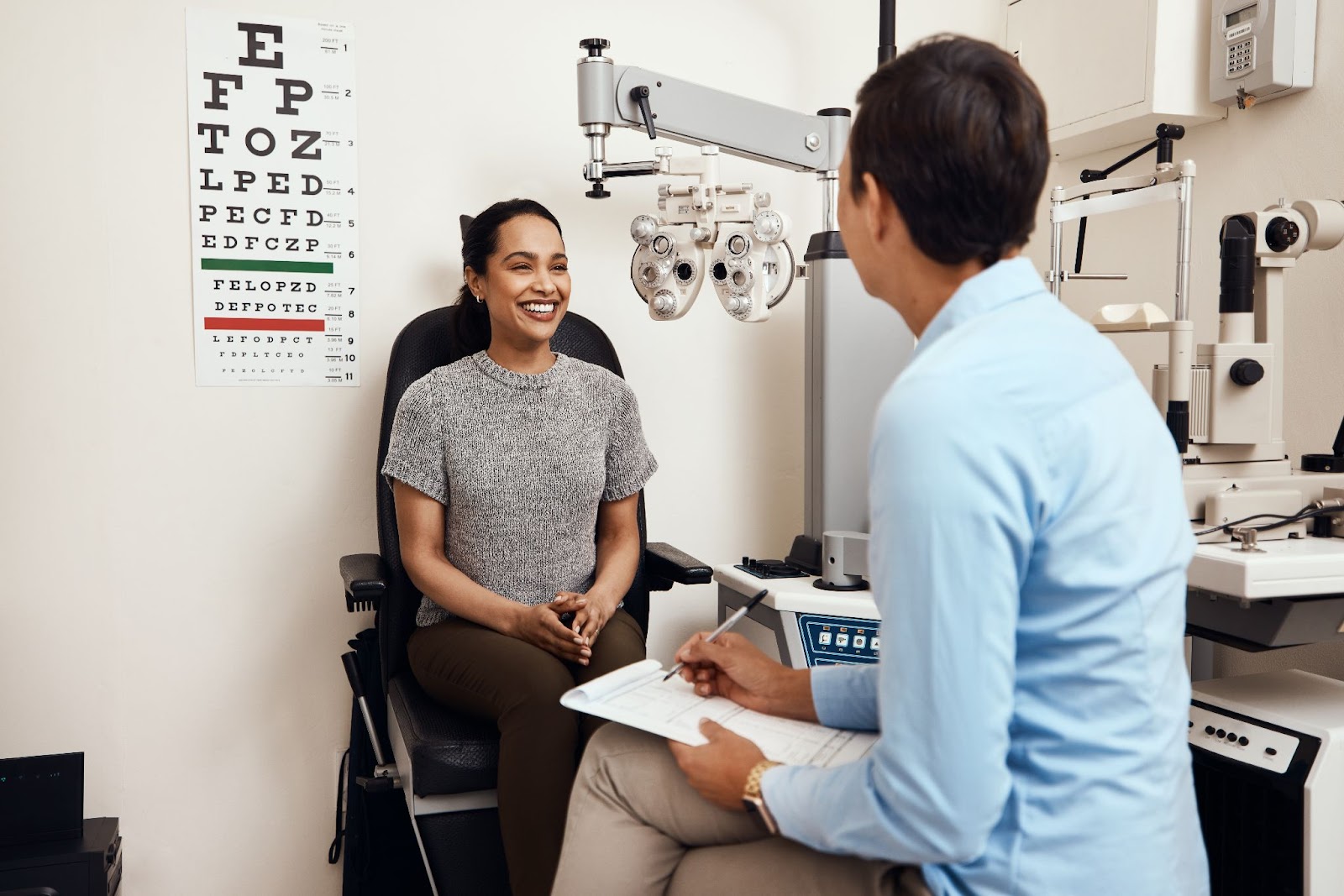 A young female patient and a male optometrist discussing the results of an eye exam.