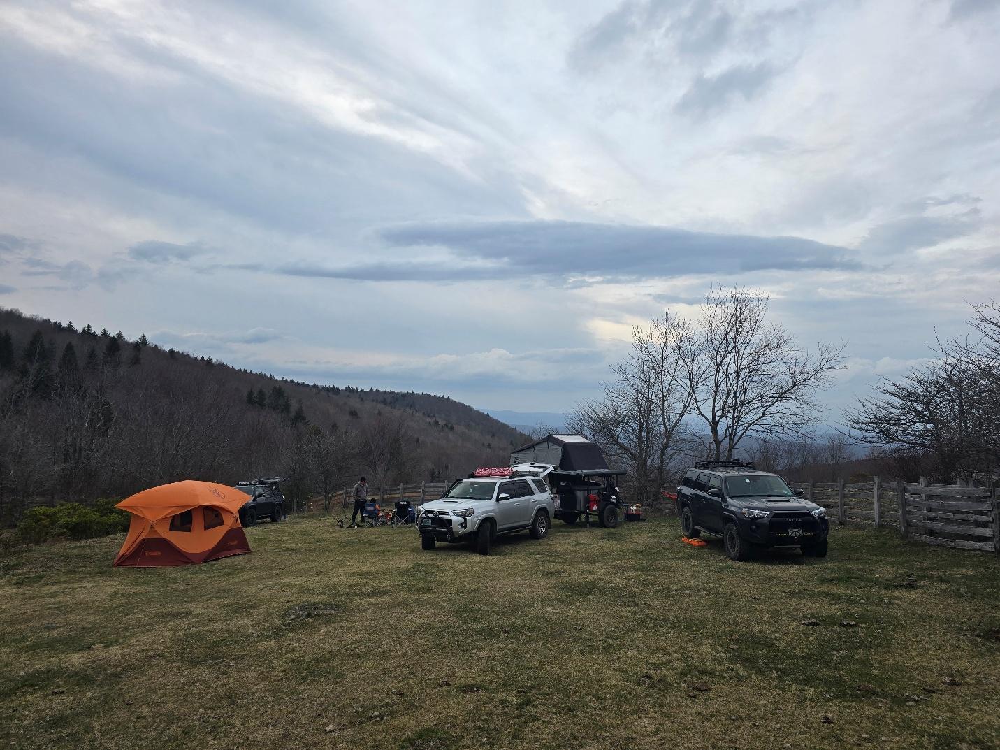 A group of cars parked in a grassy area with tents

AI-generated content may be incorrect.
