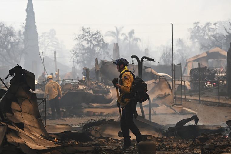 Firefighters work inside a burned structure while battling the Eaton Fire.