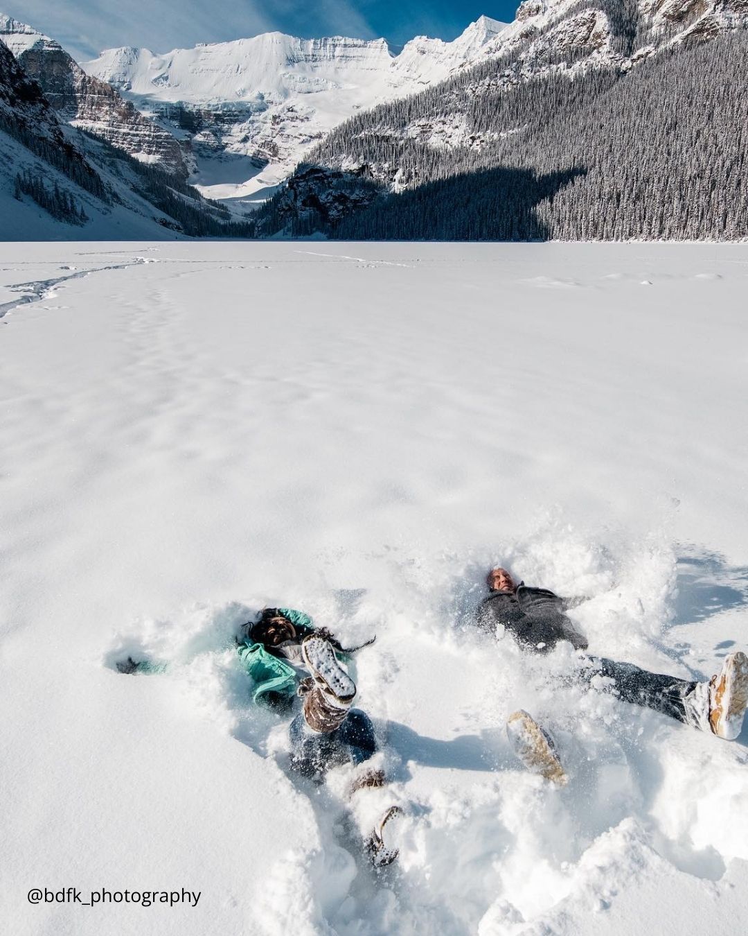 winter engagement photos love couple laying in the snow