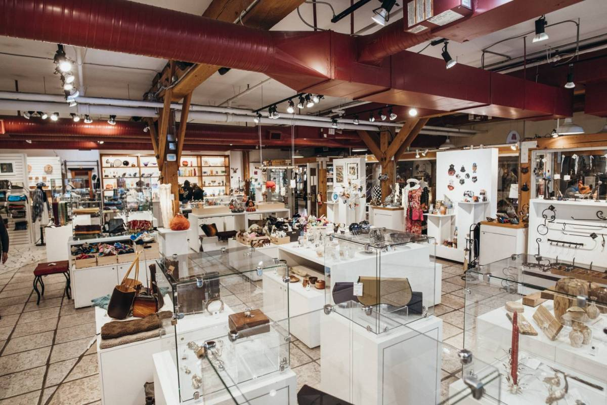 The interior of Circle Craft on Granville Island, showing all kinds of creations on white podiums