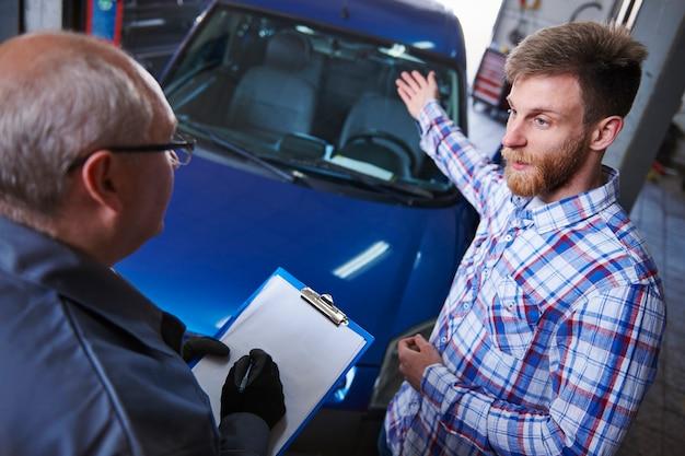 Customer talking with a mechanic in the workshop