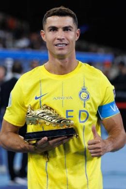 Nassr's Portuguese forward Cristiano Ronaldo poses with the top goalscorer trophy after winning the 2023 Arab Club Champions Cup after their final...