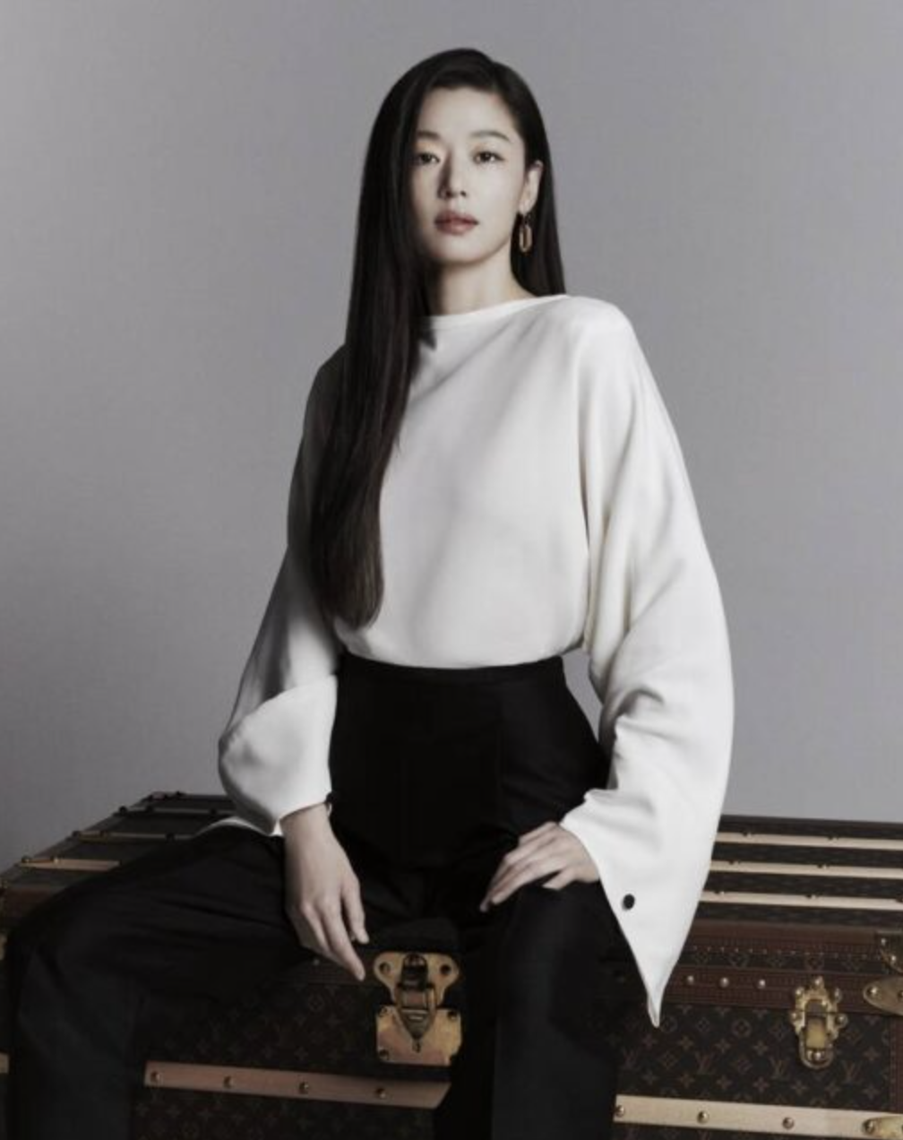 Jun Ji Hyun wearing a white dress and a black trouser sitting on a box 