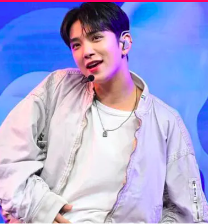 This contain an image Joshua putting on white jacket and a white inner shirt smiling