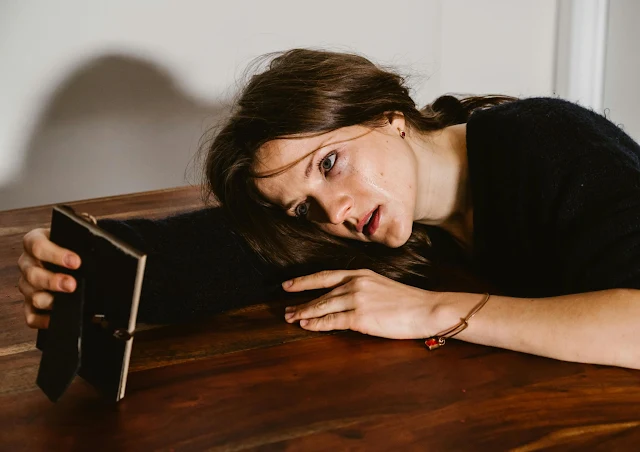 woman loking sad a photo of loved one