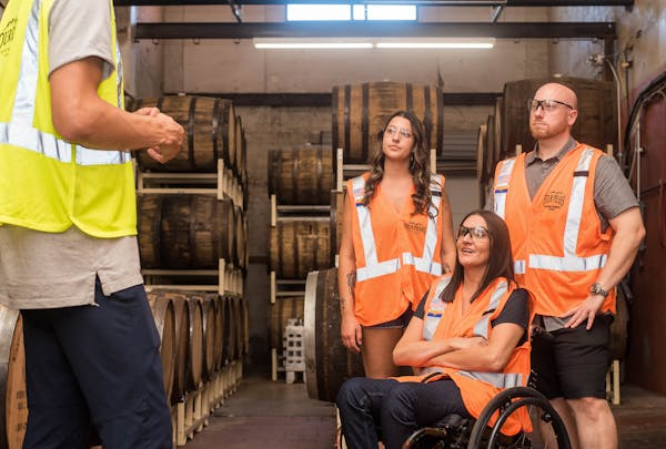 woman in a wheelchair happily talking with her coworkers