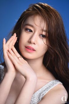 This contains an image of jiyeon on a blue background clapping her hands