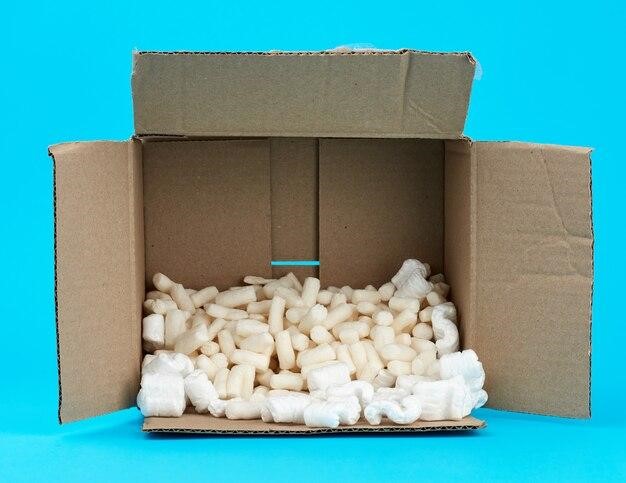 Open rectangular brown cardboard box with white foam filling for transporting goods