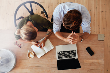 how tariffs will affect your home remodeling project couple planning remodel together at kitchen table custom built michigan