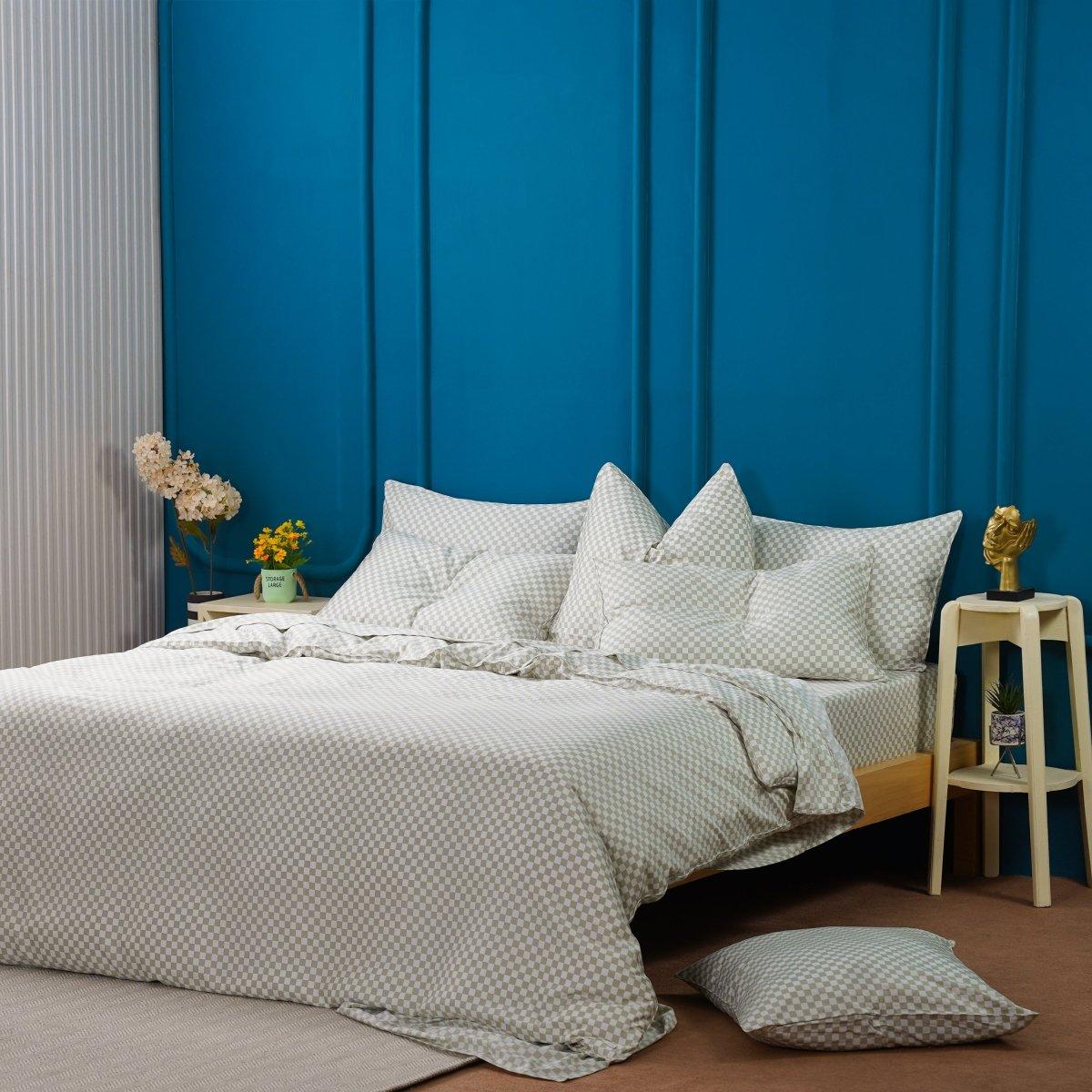 A bed with pillows and a blue wall