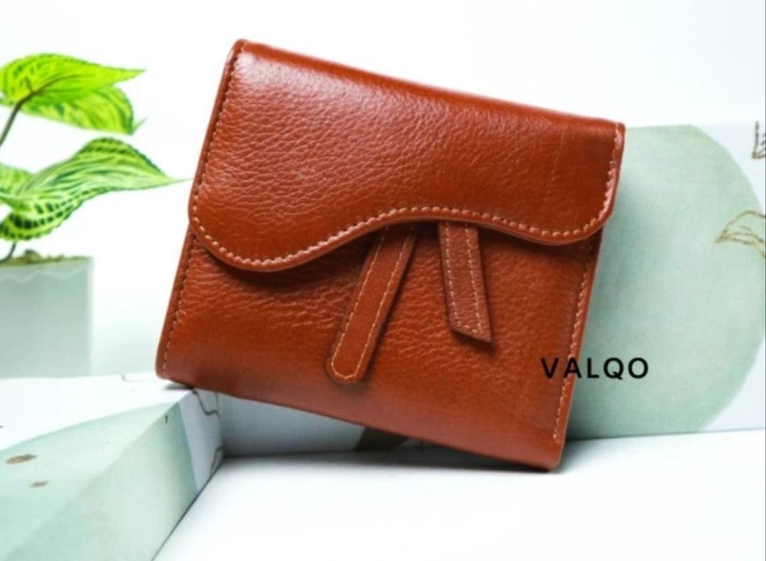 A brown leather wallet on a white surface

Description automatically generated