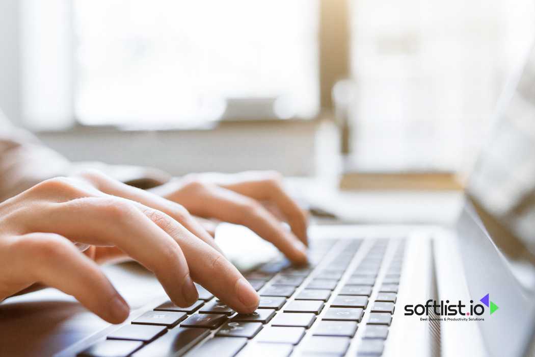 Hands typing on a laptop keyboard with sunlight