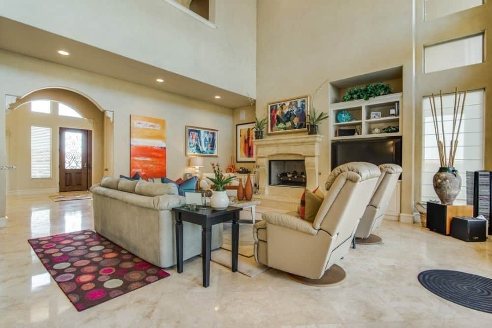 Family room with leather seats, a TV, and a marble fireplace.