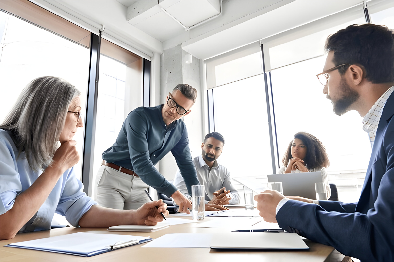 A team of professionals collaborating during the post-merger integration process, with accountants leading the discussion to ensure smooth financial transition and alignment.