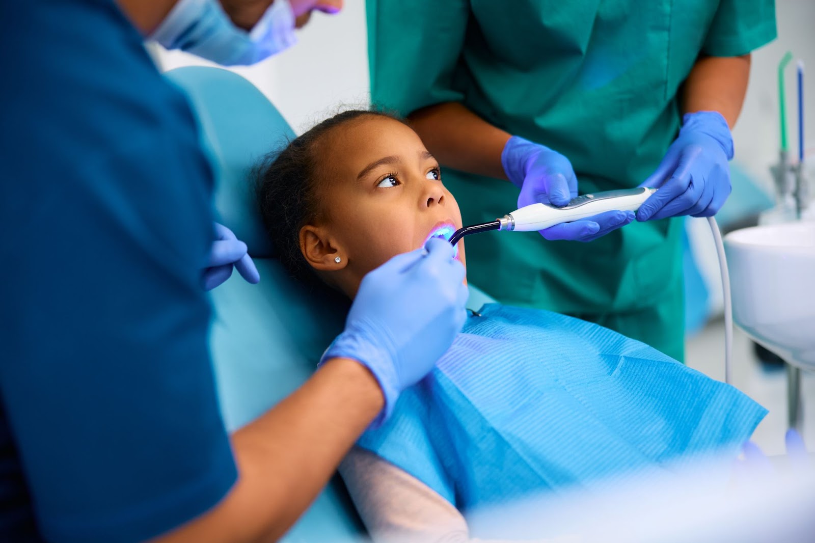 A young girl undergoes a dental procedure at a dental clinic.