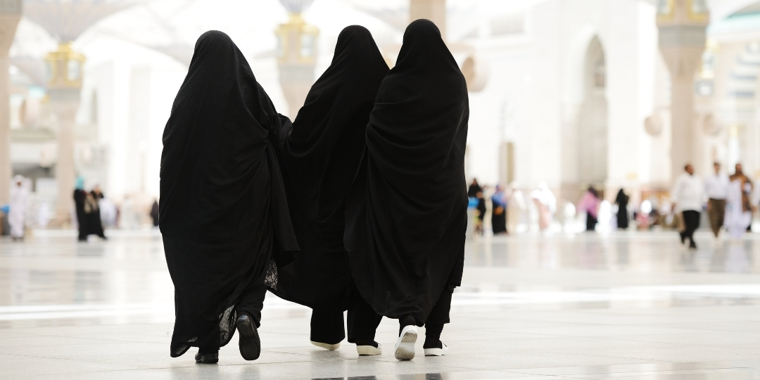 Women walking in black Abayas inside a Mosque - (Credits Family Travel in the Middle East)
