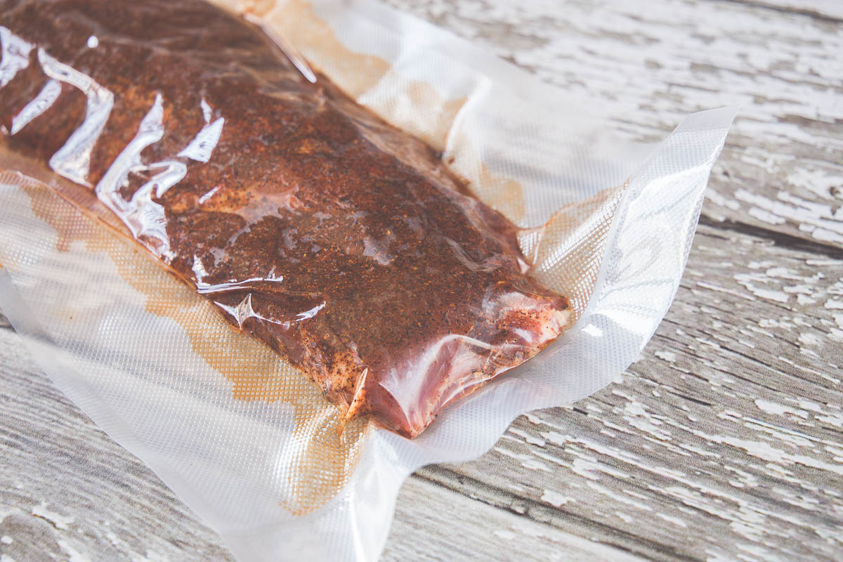 Preparing ribs in a vacuum sealed bag before grilling