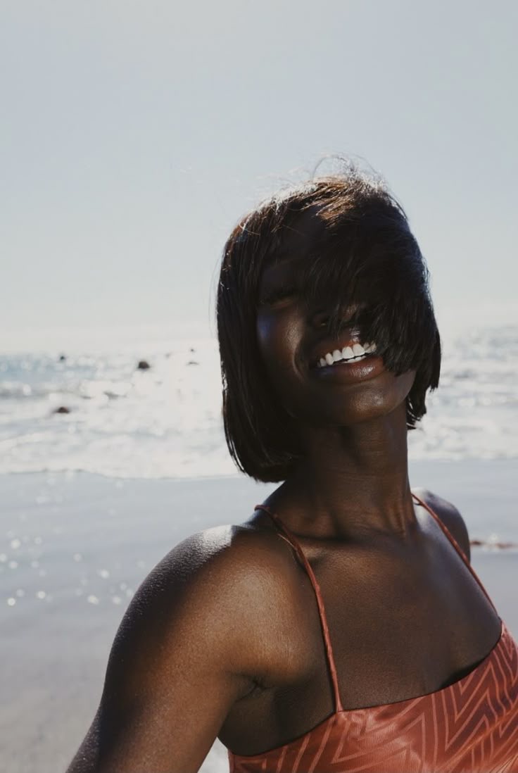 Alt Image: Black woman at the beach, looking happy. Image sourced from Pinterest (original creator unknown). If this is your work, please contact us for proper credit.