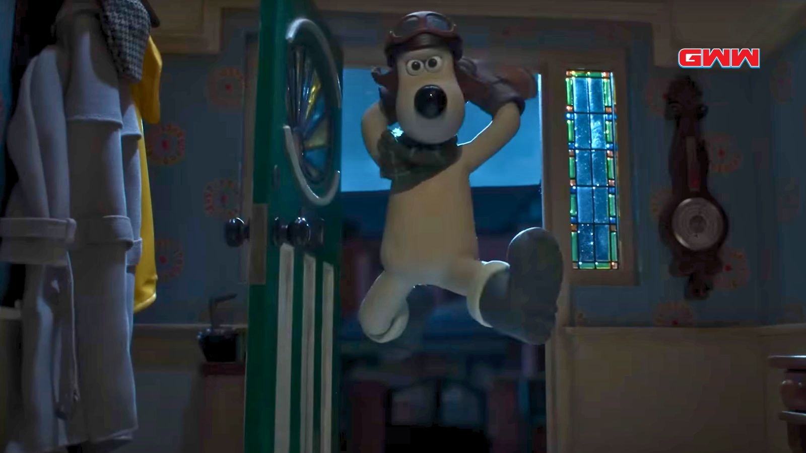 Gromit enters a room, wearing a pilot helmet and scarf.