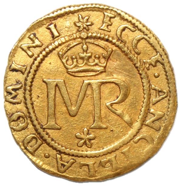 A gold coin with a crown and letters

Description automatically generated